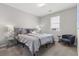 Bedroom featuring a bed, chair, side table and window with blinds at 10776 Maltese Falcon Ave, Las Vegas, NV 89129