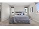 Bedroom with plush carpeting, stylish decor, and ample natural light from two windows at 10776 Maltese Falcon Ave, Las Vegas, NV 89129