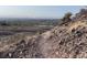 Desert path view featuring scrub vegetation, distant horizon, and a bright, clear sky at 10776 Maltese Falcon Ave, Las Vegas, NV 89129