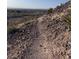 Winding desert trail overlooking a landscape with sparse foliage and city skyline in the distance at 10776 Maltese Falcon Ave, Las Vegas, NV 89129