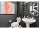 Stylish powder room featuring a sleek pedestal sink, geometric mirror, and dark accent wall at 10776 Maltese Falcon Ave, Las Vegas, NV 89129