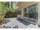 Outdoor patio and sliding glass doors leading into the home, surrounded by lush trees and landscaping at 11377 Gravitation Dr, Las Vegas, NV 89135