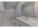 Modern bathroom featuring a glass-enclosed shower, white vanity with solid surface counter and marble-look tile flooring at 11377 Gravitation Dr, Las Vegas, NV 89135