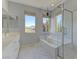 Bright primary bathroom with double sinks, soaking tub, and glass-enclosed shower with marble floors at 11377 Gravitation Dr, Las Vegas, NV 89135