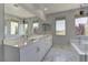 Modern primary bathroom with double sinks, soaking tub, and a separate shower, along with marble floors at 11377 Gravitation Dr, Las Vegas, NV 89135