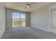 This bedroom offers carpet, large windows, and a sliding glass door leading to a balcony at 11377 Gravitation Dr, Las Vegas, NV 89135