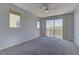 Spacious bedroom with plush carpeting, a ceiling fan, large windows, and a sliding glass door to the balcony at 11377 Gravitation Dr, Las Vegas, NV 89135