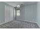 Bright bedroom featuring a chandelier, light gray walls, and white trim around the baseboards and window at 11377 Gravitation Dr, Las Vegas, NV 89135
