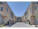 Modern townhomes feature neutral stucco exteriors, garages, and a paved driveway under a clear blue sky at 11377 Gravitation Dr, Las Vegas, NV 89135