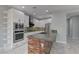 Bright kitchen with white cabinets, stainless appliances, and sleek modern vent hood at 11377 Gravitation Dr, Las Vegas, NV 89135