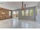 Bright living room featuring marble floors, unique accent wall, modern light fixtures, and sliding glass doors to the backyard at 11377 Gravitation Dr, Las Vegas, NV 89135
