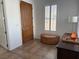 Inviting entryway with a wooden front door, window with shutters, and an ottoman for convenience at 1146 Olivia Pkwy, Henderson, NV 89011