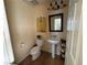 Cozy half bath with pedestal sink, decorative mirror, and neutral color scheme at 1146 Olivia Pkwy, Henderson, NV 89011