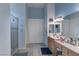 Bright bathroom featuring double sinks, ample counter space, a glass-enclosed shower and tile flooring at 1239 N Hollywood Blvd, Las Vegas, NV 89110