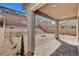 Backyard boasts rock landscaping, small trees and shrubbery, covered patio with brick, and brick wall at 15 Santo Mio Ct, Henderson, NV 89011