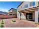 Backyard boasts rock landscaping, small trees and shrubbery, covered patio with brick, and brick wall at 15 Santo Mio Ct, Henderson, NV 89011