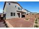 Backyard with rock landscaping, small trees and shrubbery, covered patio, brick wall, and partial view at 15 Santo Mio Ct, Henderson, NV 89011