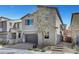 View of a two-story home with gray exterior paint, a two-car garage and desert landscaping in the front at 15 Santo Mio Ct, Henderson, NV 89011