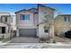 Two-story home features a gray exterior, attached two-car garage, paver driveway, and manicured landscaping at 15 Santo Mio Ct, Henderson, NV 89011
