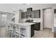 Modern kitchen features dark cabinets, stainless steel appliances, a kitchen island with white countertop and barstool seating at 15 Santo Mio Ct, Henderson, NV 89011