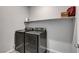 Laundry room features gray front load washer and dryer, shelf with décor, and neutral walls at 15 Santo Mio Ct, Henderson, NV 89011