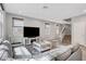Living room featuring plush gray sofa, modern TV, and staircase at 15 Santo Mio Ct, Henderson, NV 89011