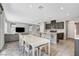 Open-concept living room and kitchen with modern gray cabinets, a large island, and a white dining set at 15 Santo Mio Ct, Henderson, NV 89011