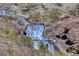 Picturesque waterfall cascading down a rocky hillside with desert plants at 15 Santo Mio Ct, Henderson, NV 89011