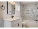 Updated bathroom with marble tile, white vanity, and tub with shower at 1641 K St, Las Vegas, NV 89106