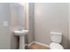 Small half bath with pedestal sink, toilet, and neutral walls at 176 Dunblane St, Henderson, NV 89012