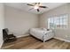 This is a bedroom with wood floors, a white bed, a rocking chair and a ceiling fan at 176 Dunblane St, Henderson, NV 89012