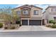 Charming two-story home with a two-car garage and stone accents, set against a bright blue sky at 176 Dunblane St, Henderson, NV 89012