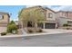 Inviting two-story home with stone facade, mature tree, two-car garage, and well-maintained landscaping at 176 Dunblane St, Henderson, NV 89012