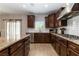 Modern kitchen with granite countertops, stainless steel appliances, and dark wood cabinets at 176 Dunblane St, Henderson, NV 89012