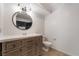 Bathroom featuring a wood vanity, white counter, round mirror and tiled floors at 1804 Michael Ct, Henderson, NV 89014