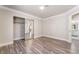 Bright bedroom featuring wood-look floors and mirrored closet doors with a view into the bathroom at 1804 Michael Ct, Henderson, NV 89014