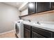Laundry room featuring a new washer and dryer, plus a sink with dark cabinetry at 1804 Michael Ct, Henderson, NV 89014