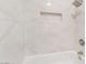 This shower and tub combination is surrounded by white marble tile with a built in shelf at 1804 Michael Ct, Henderson, NV 89014