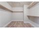 Bright walk-in closet features wood-look floors and ample storage with wooden rods and shelving at 1804 Michael Ct, Henderson, NV 89014