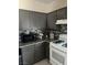 Contemporary kitchen featuring gray cabinets, granite counters, and modern appliances at 1830 N Buffalo Dr # 2021, Las Vegas, NV 89128