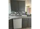 Modern kitchen with gray cabinets, granite countertops, and a stylish tile backsplash at 1830 N Buffalo Dr # 2021, Las Vegas, NV 89128