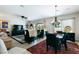 Open concept dining area with a stylish chandelier, tile floors, and adjacent living space at 2188 Cumberland Hill Dr, Henderson, NV 89052