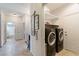 Bright laundry room with side by side washer and dryer and built-in shelving at 2188 Cumberland Hill Dr, Henderson, NV 89052