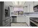 Bright kitchen featuring white cabinets, stainless steel appliances, and a window providing natural light at 2558 La Fortuna Ave, Las Vegas, NV 89121