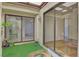 Enclosed patio connecting two rooms with artificial turf, plants, and sliding glass doors at 2558 La Fortuna Ave, Las Vegas, NV 89121
