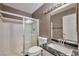 Bathroom featuring a black marble countertop, white tile, and a glass-enclosed shower at 3151 Soaring Gulls Dr # 2050, Las Vegas, NV 89128