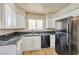 Kitchen features white cabinets, granite countertops, and black appliances at 3151 Soaring Gulls Dr # 2050, Las Vegas, NV 89128