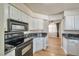 Bright kitchen with white cabinets, black appliances, and granite countertops at 3151 Soaring Gulls Dr # 2050, Las Vegas, NV 89128
