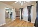 Living room with wood floors, windows with curtains, ceiling fan, and kitchen access at 3151 Soaring Gulls Dr # 2050, Las Vegas, NV 89128