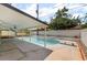 Inviting pool with a diving board, covered patio, and lush landscaping for backyard enjoyment at 3463 Haverford Ave, Las Vegas, NV 89121